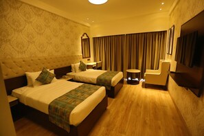 Two large beds with matching headboards and a small round table for convenient storage.