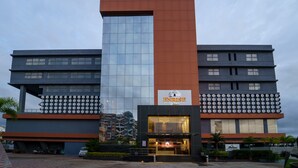 Un hotel moderno con una fachada vertical llamativa en naranja y gris, ventanas grandes y un letrero que dice "ENRISE".