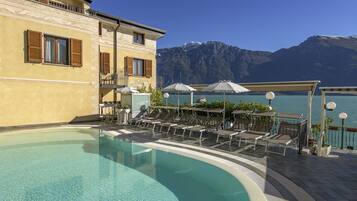 Piscine extérieure, parasols de plage, chaises longues