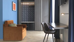 A modern living room with a sofa, a dining table, and a kitchen area in the background.