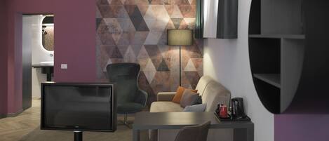 A modern living room with a flat-screen TV, a sofa, a coffee table, and a dining area with a table and chairs.