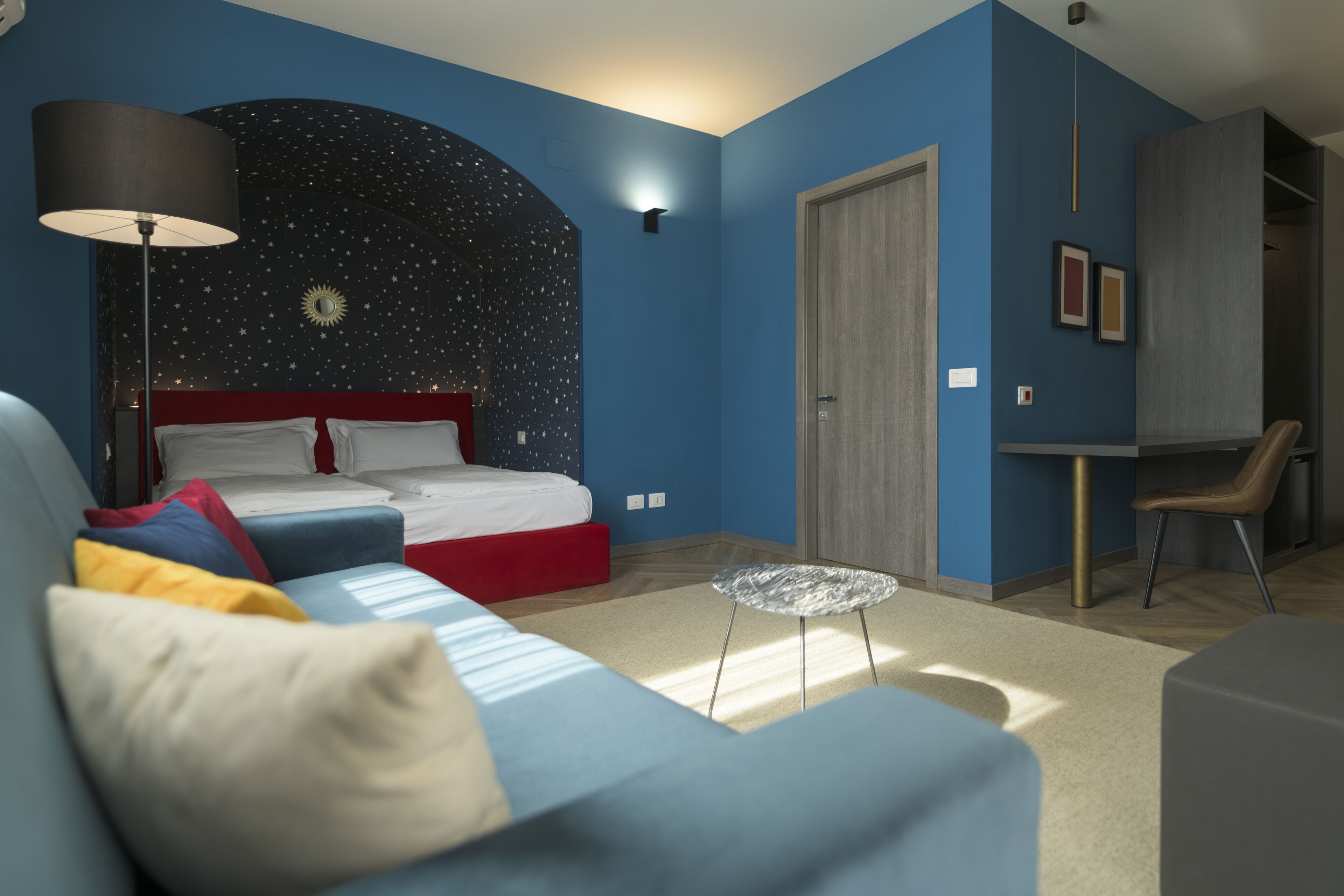 Un dormitorio moderno con cama, escritorio y sofá.