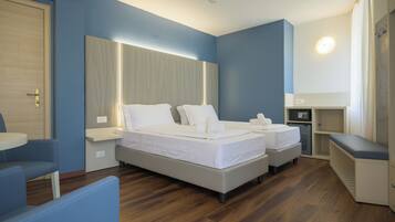 A hotel room with a large bed, bedside tables, a desk, and a chair.
