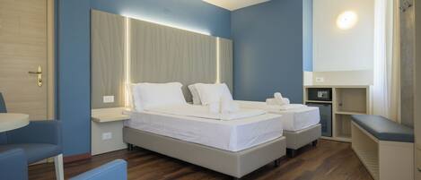 A hotel room with a large bed, bedside tables, a desk, and a chair.
