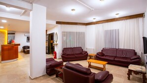 Una sala de estar moderna con chimenea, sofás de cuero, una mesa de centro de madera y un mostrador de recepción.