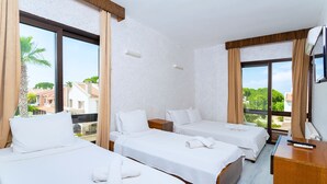 Una habitación de hotel con dos camas, un escritorio y un televisor.