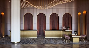 A reception area with a modern design, featuring a reception desk, two chairs, and a decorative ceiling light fixture.