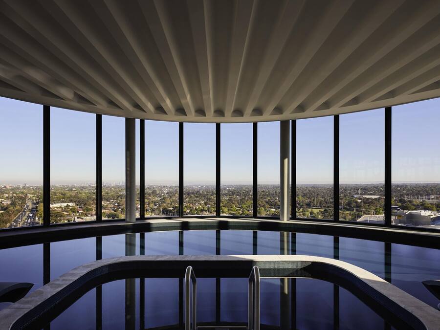 Een binnenzwembad, ligstoelen bij het zwembad