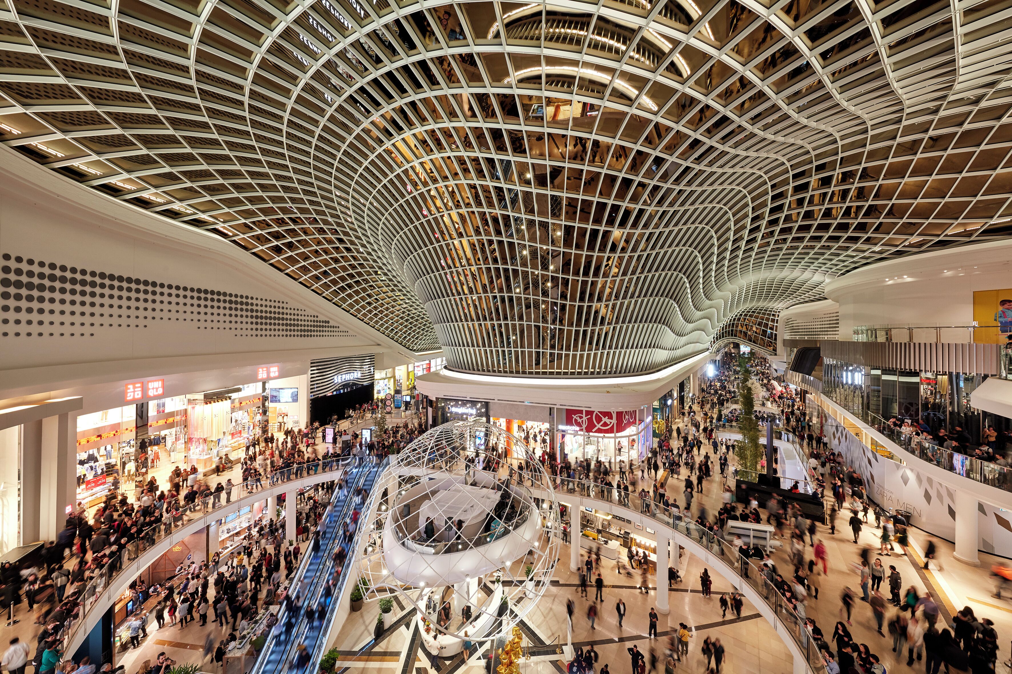 Un centro comercial de varios niveles con un techo curvo distintivo y múltiples plantas.