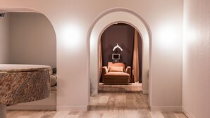 A modern bathroom with a marble sink, a massage chair, and a small TV screen. - Hotel Chadstone Melbourne MGallery Collection (Chadstone)