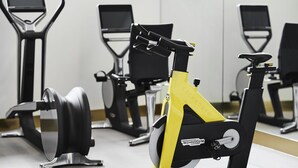 Una bicicleta estática en un gimnasio, con un espejo y otros equipos de ejercicio.