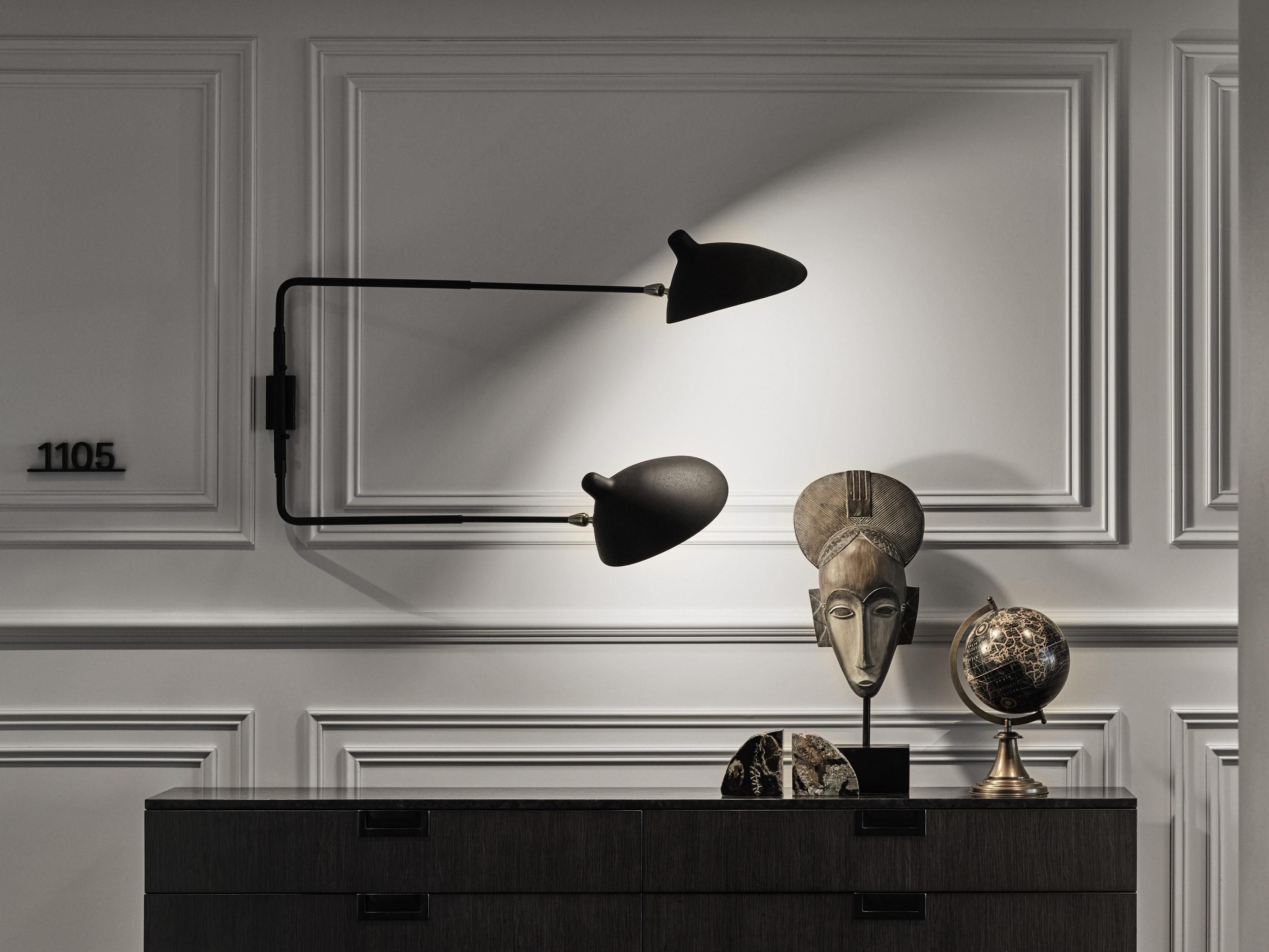 A dark wooden dresser with a globe and a bust sculpture on top.