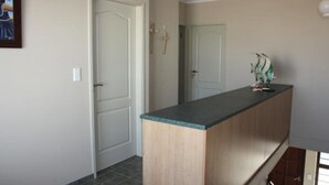 A hallway with a wooden counter and a door. - On The Dunes 8 (Henties Bay)
