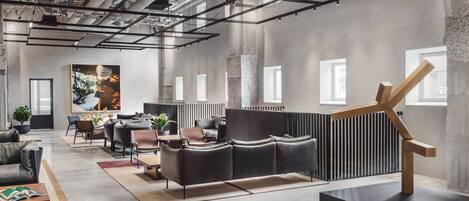 A modern interior with a sectional sofa, a coffee table, and a minimalist sculpture.