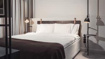 A modern bedroom with a large bed, a bedside table, and a floor lamp.