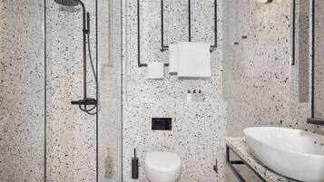 A modern bathroom with a freestanding bathtub, a toilet, and a large sink.