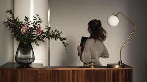 A reception desk with a vase of flowers, a desk lamp, and a bell. - Bob W Helsinki Ullanlinna (Helsinki)