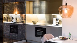 A modern kitchen with a dining area, including a table, chairs, and a hanging light fixture. - Bob W Helsinki Ullanlinna (Helsinki)