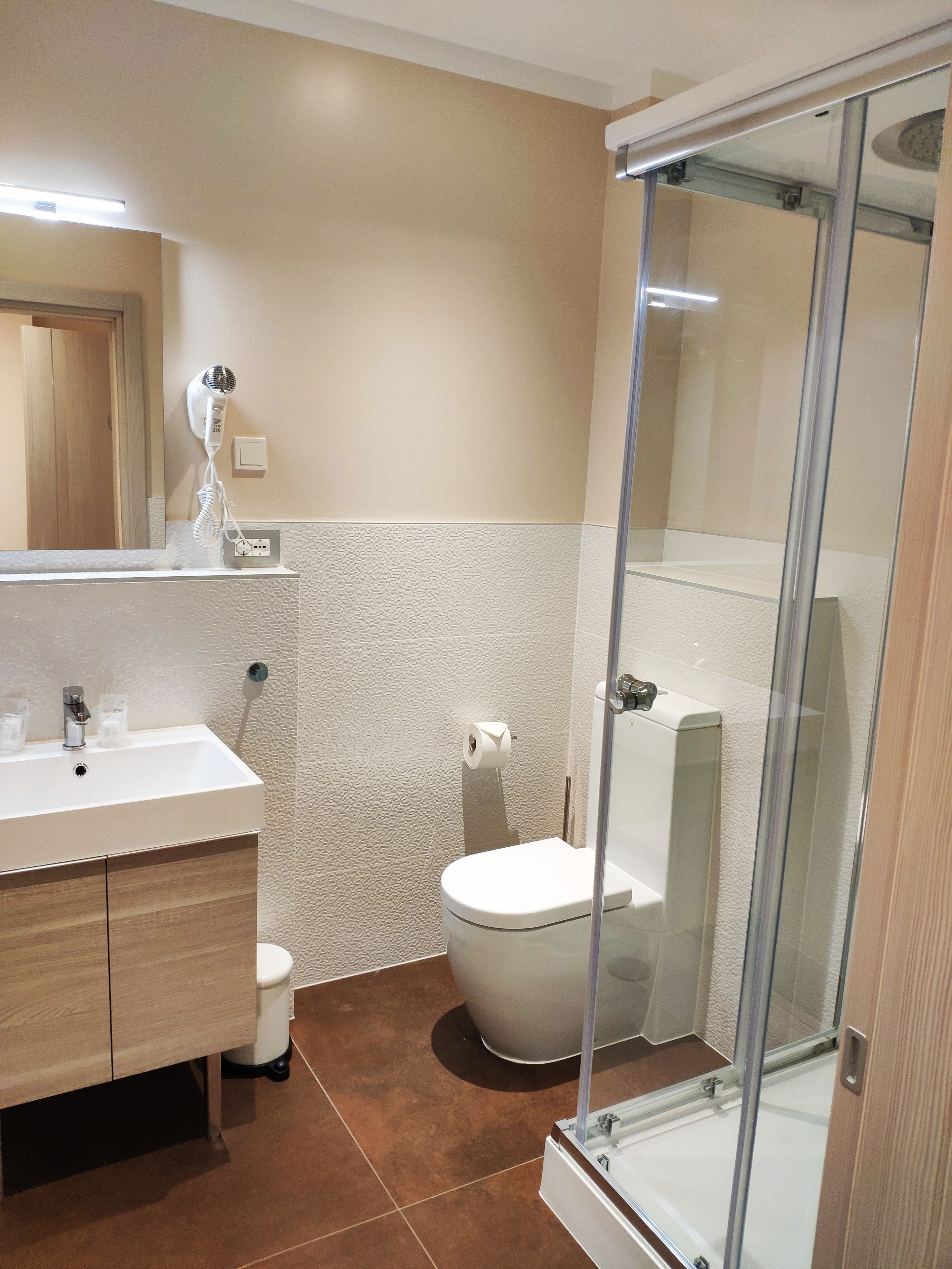 Deluxe tweepersoonskamer | Badkamer | Een douche, een regendouche, een haardroger, handdoeken