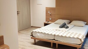 Une chambre à coucher moderne avec un lit en bois, une table de chevet et une commode.