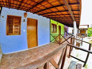 Un edificio con fachada azul, una puerta de madera y el número 2 en la pared.