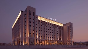 A modern hotel building with a prominent 'ROVE' sign on the facade, featuring a symmetrical design with evenly spaced windows and a central entrance. - Rove At The Park (Dubai)