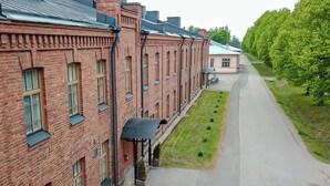 Ein längeres Backsteingebäude mit zahlreichen Fenstern und einem überdachten Gang.