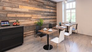 Ein moderner Essbereich mit Holzwandverkleidung, einer schwarzen Küchenarbeitsplatte und einem Fenster, das natürliches Licht hereinlässt.