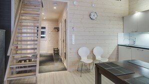 Une cuisine moderne avec des murs en bois, une horloge intégrée et un escalier menant à une autre pièce.