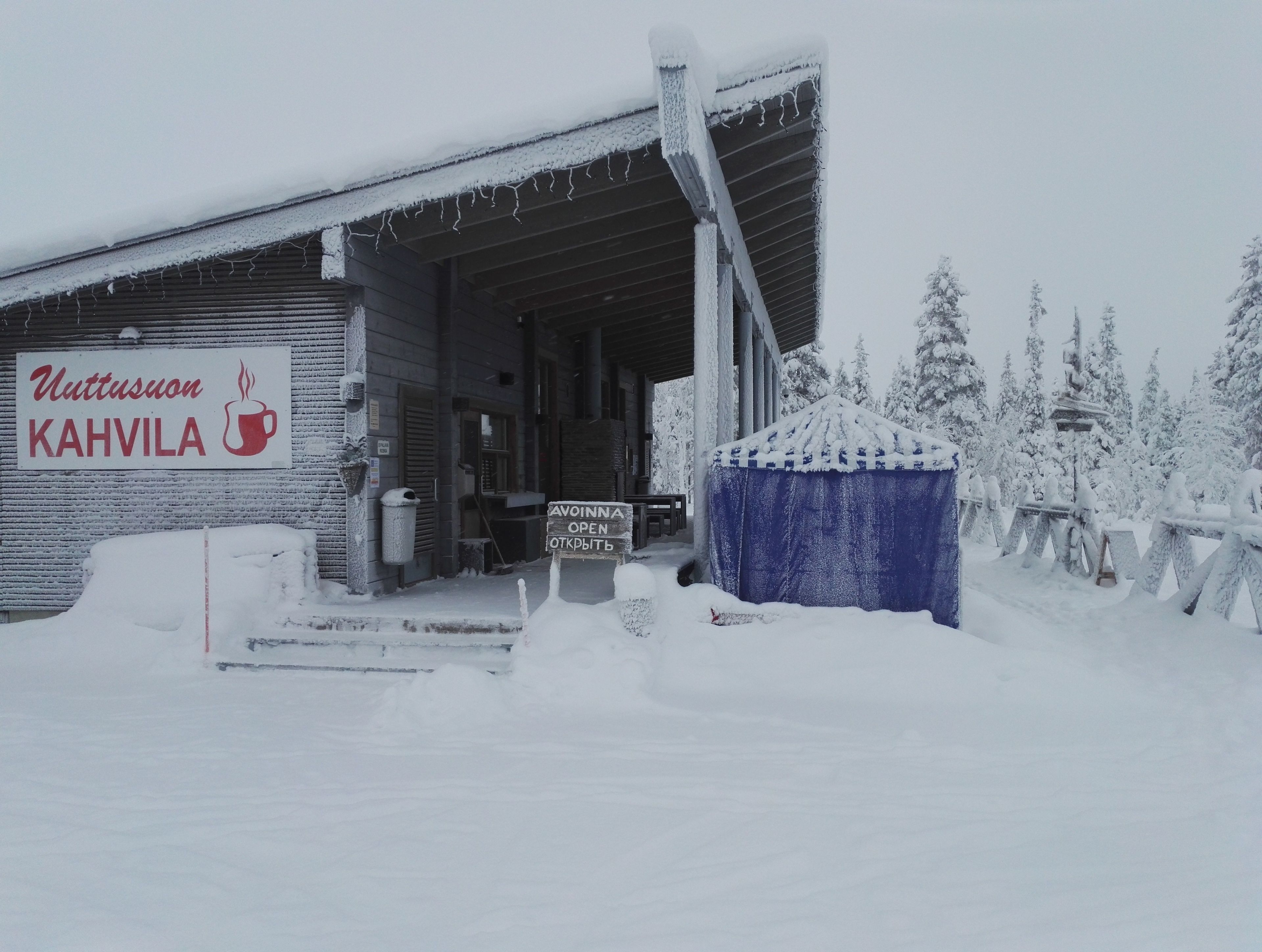 A snow-covered building with a sign reading "Uttusuon KAHVILA".