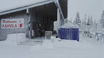 A snow-covered building with a sign reading "Uttusuon KAHVILA".