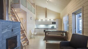 Un espace de vie moderne de style loft, doté d’une cheminée, d’un coin repas et d’une cuisine.