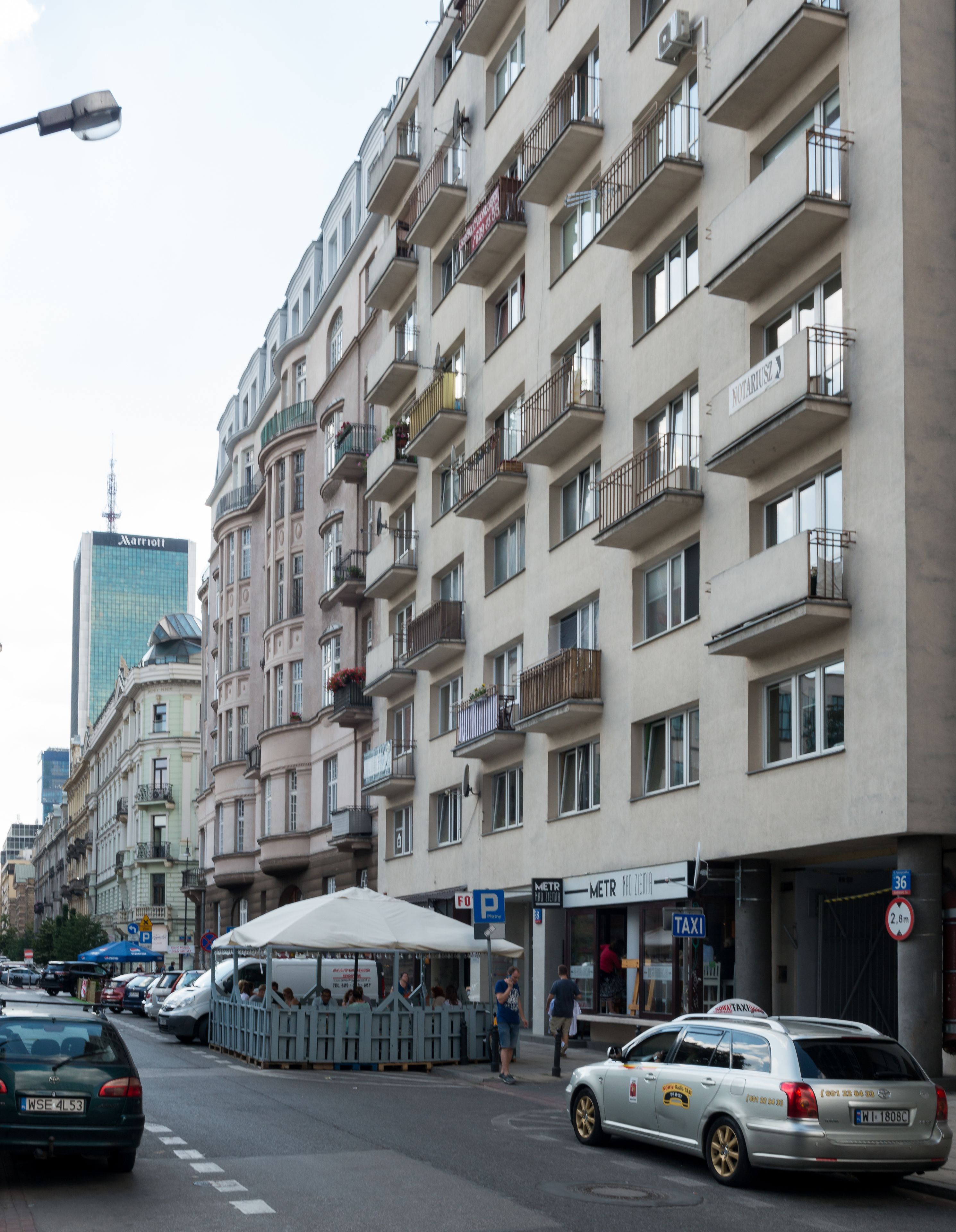 A multi-story building with balconies, a visible 'Marriott' sign, and a 'TAXI' sign.