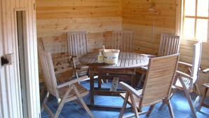 Eine Holzhütte mit einem runden Tisch und sechs Stühlen.