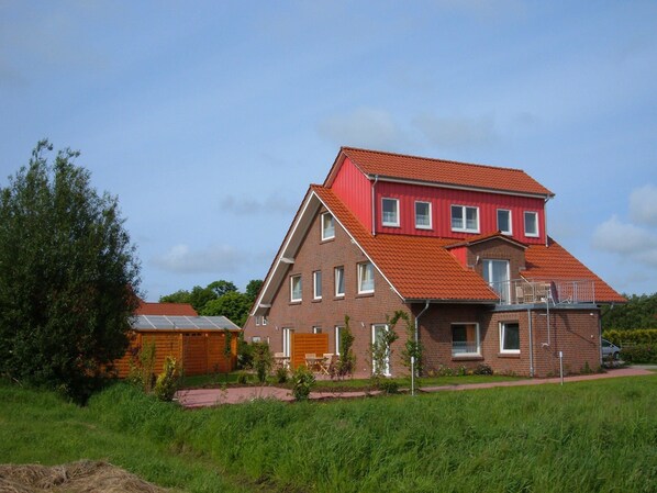 Una casa de dos pisos con techo rojo y fachada de ladrillo.