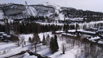 A snow-covered mountain with a ski lift and a residential area with houses.