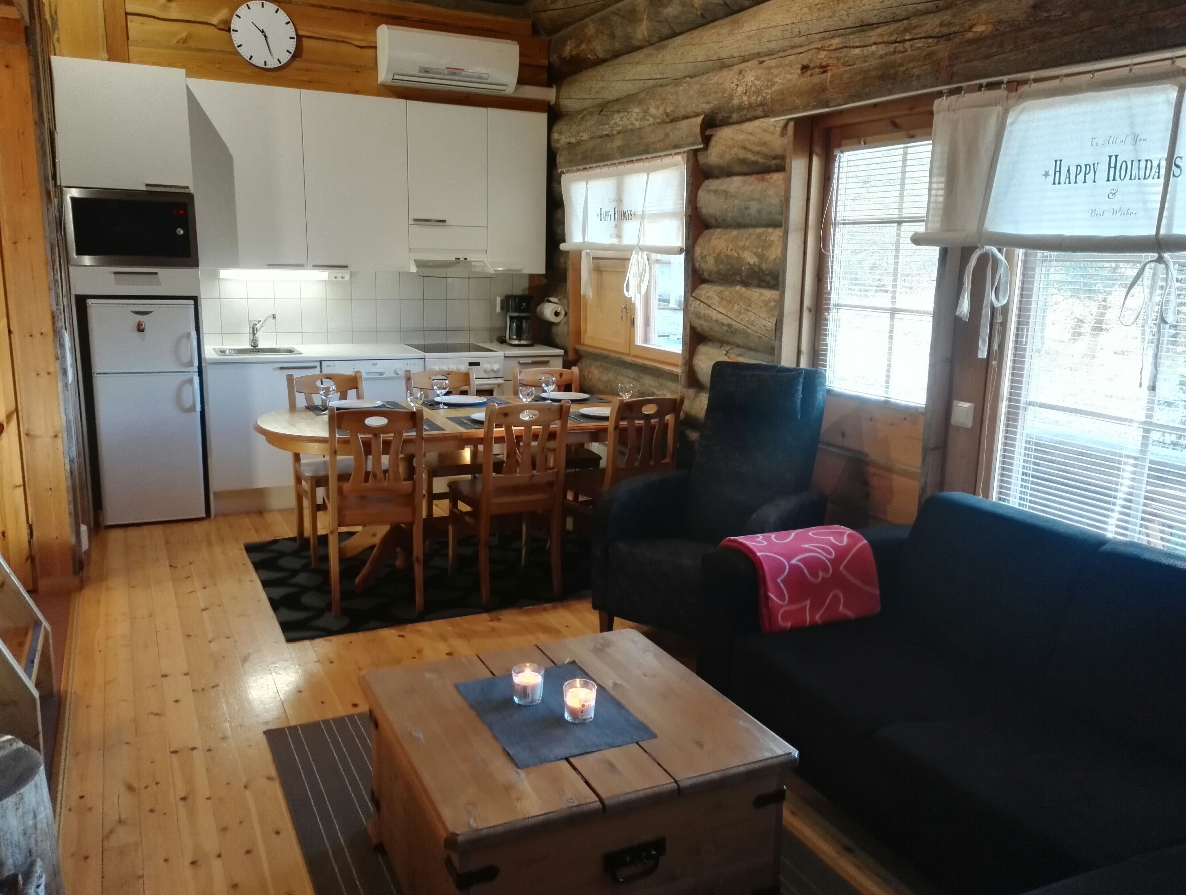 Un intérieur de chalet chaleureux comprenant un coin repas, une cuisine et un espace salon.