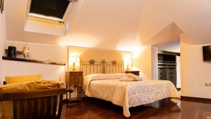A bedroom with a bed, bedside table, lamp, and a small table with a vase. - Real Borbone (Caserta)