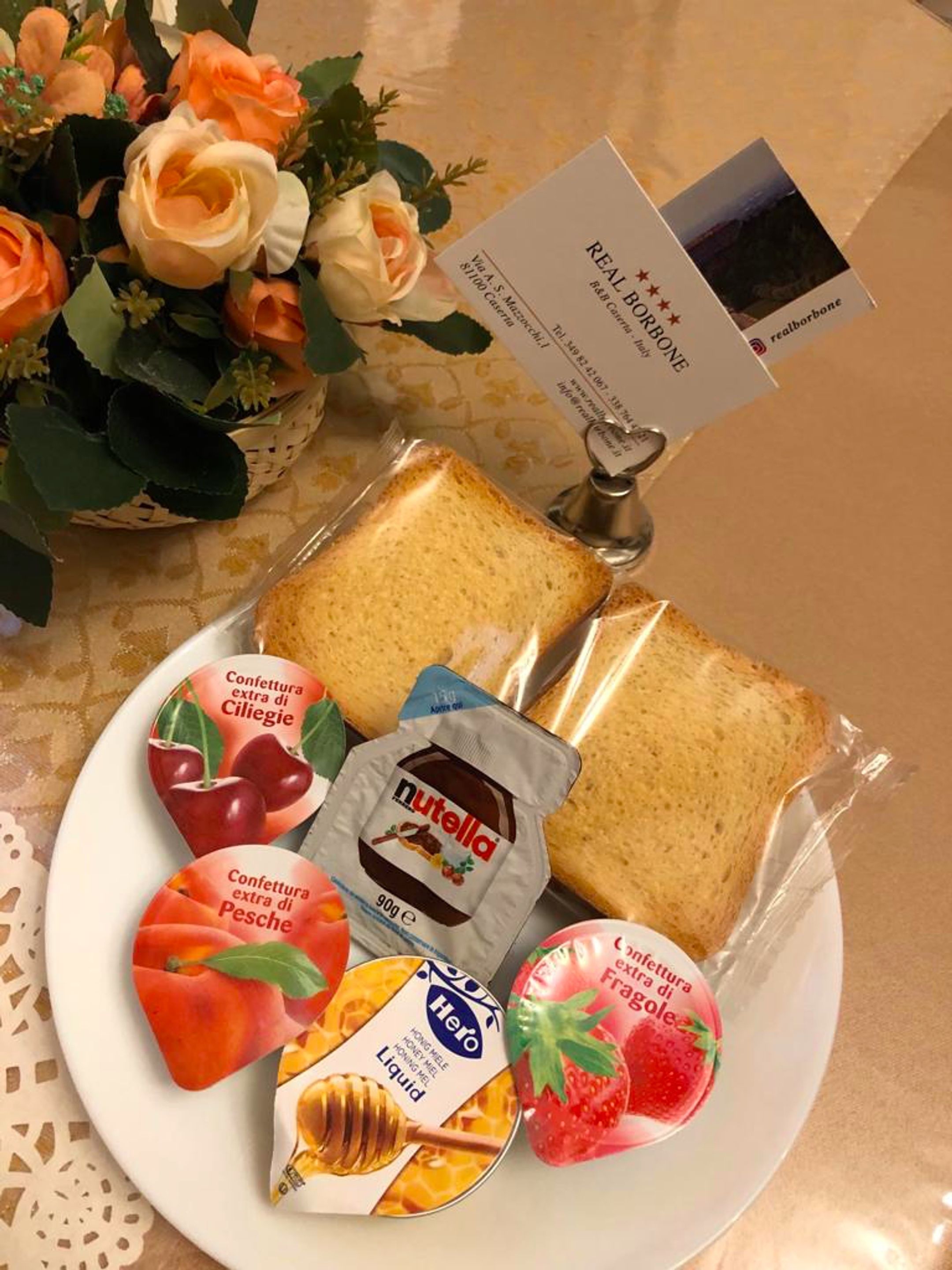 Ein Teller mit Brot, Nutella und verschiedenen Marmeladen und Honig.