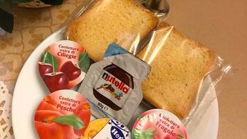 Ein Teller mit Brot, Nutella und verschiedenen Marmeladen und Honig.