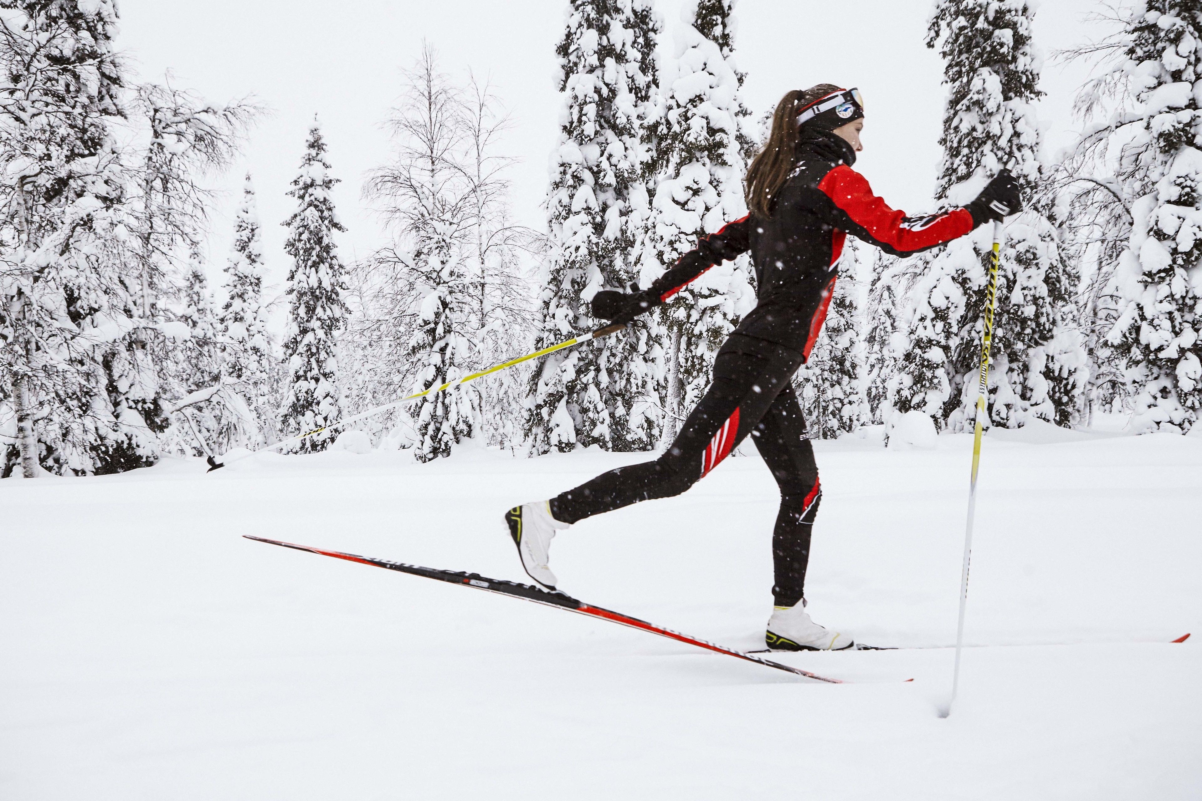 Eine Person fährt im verschneiten Wald Ski.