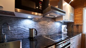 Una cocina moderna con protector contra salpicaduras de piedra, electrodomésticos de acero inoxidable y horno empotrado.
