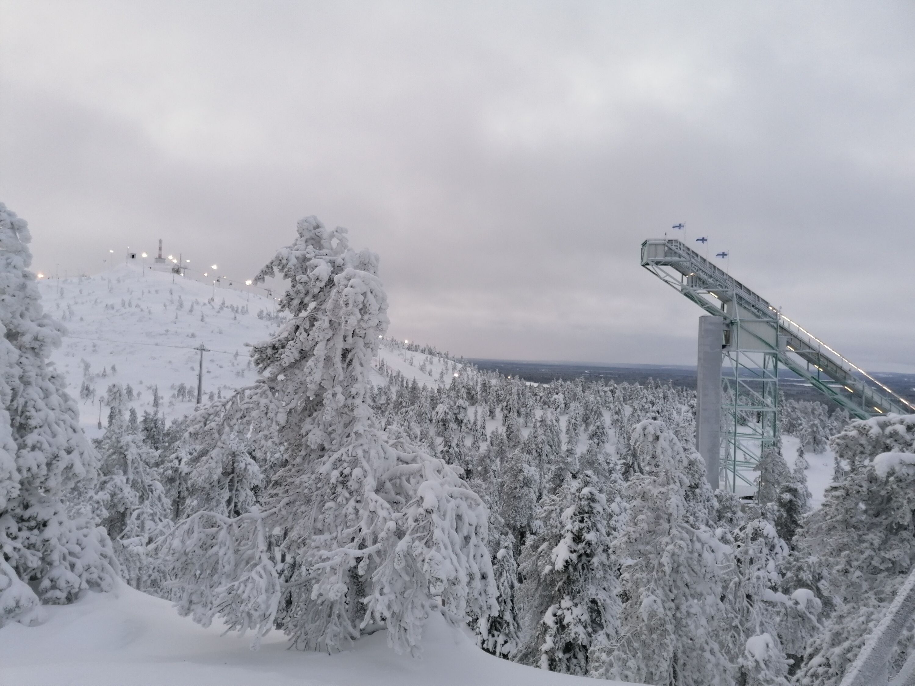 Un paysage enneigé avec un télésiège et des arbres couverts de neige.