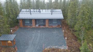 A lodge with a metal roof, two main doors, and a gravel driveway.