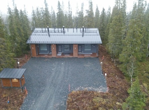 A lodge with a metal roof, two main doors, and a gravel driveway.
