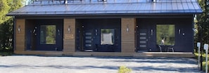A modern building with a metal roof, wooden paneling, and large windows.