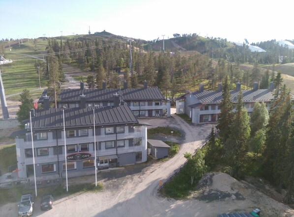A residential area with multiple houses, a cafe, and a dirt road. - Vuosselin Helmi (Kuusamo)
