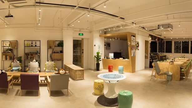 A spacious hotel lobby with a reception desk, seating area, and a stage. - Phoenix Egg Youth Hostel (Zhuhai)
