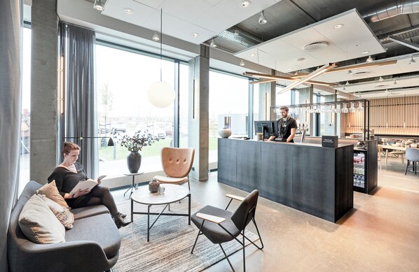 A modern reception area with a bar, seating, and large windows.