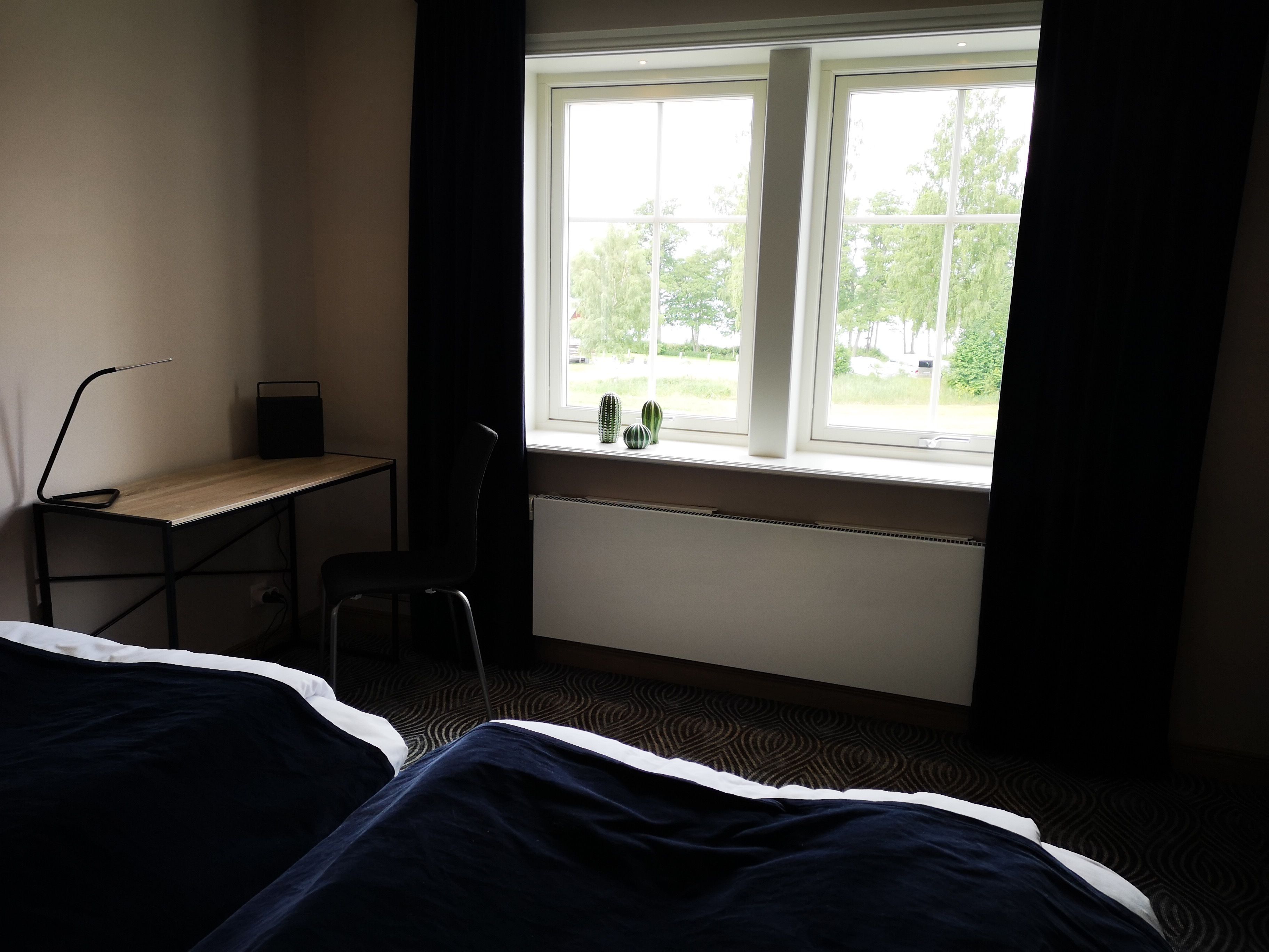 Un dormitorio con una cama individual, un escritorio y una silla cerca de una ventana.